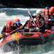 Beidhändige Führung: Gruppe (Team) im Schlauchboot beim Rafting.